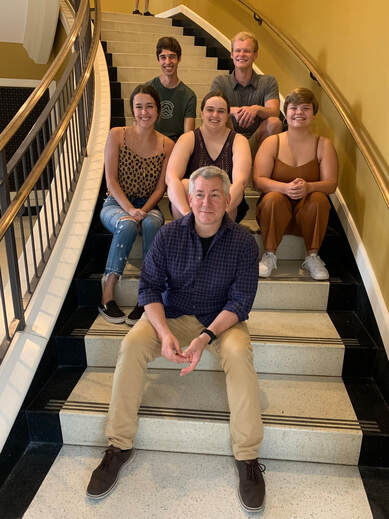 Photograph of Brad Pierce with five students sitting on the steps in Shelby Hall